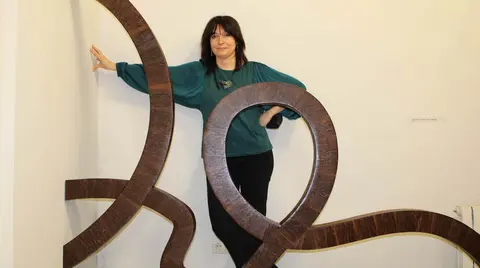 La artista Susan Bart, junto a una de sus obras